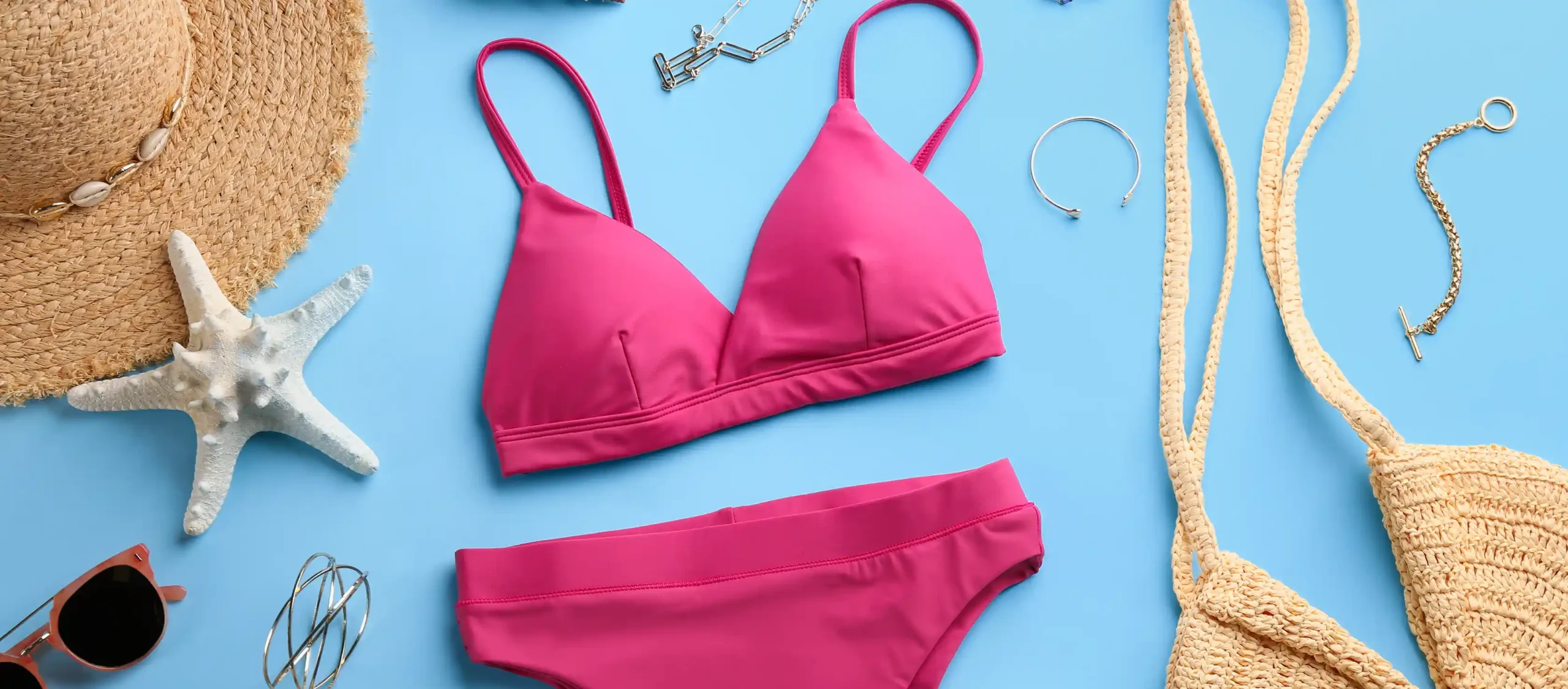 Bikini und andere Strandaccessoires auf blauem Grund