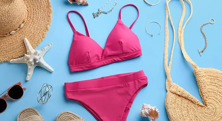 Bikini und andere Strandaccessoires auf blauem Grund